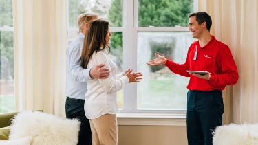 Glass Doctor professional speaking with couple in their home.